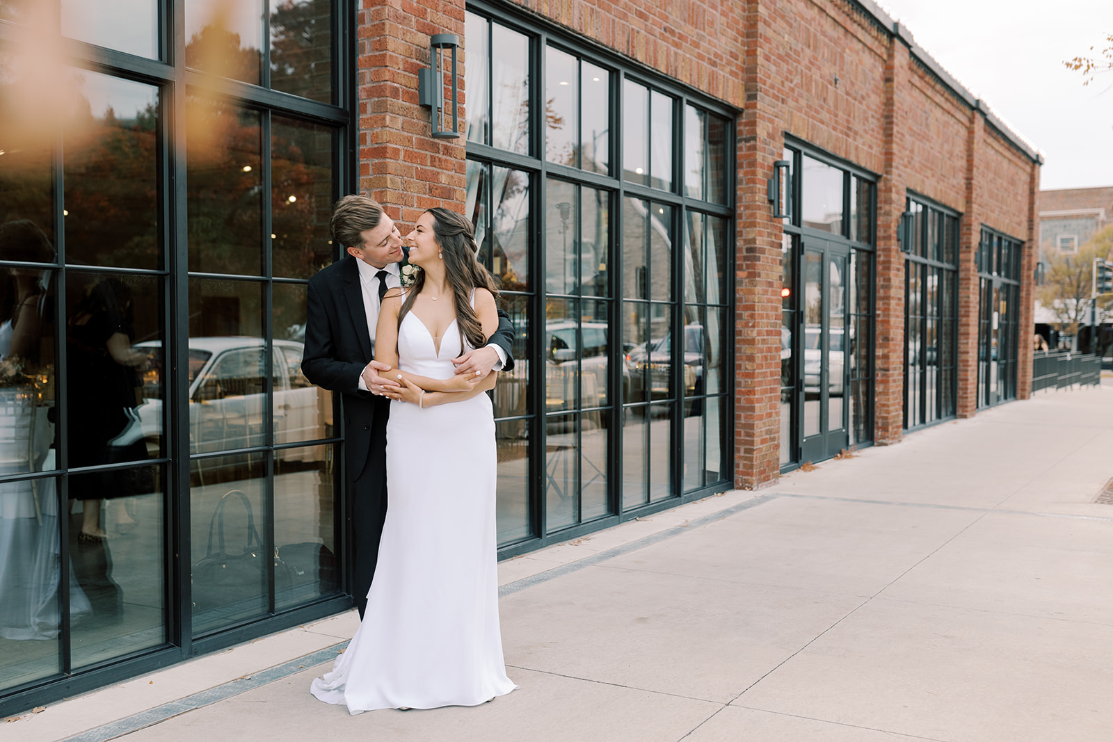 Bride and groom kiss outside wedding venue next to convertible in Jefferson City, Missouri. Day of wedding coordinator by Andrea Lyn Events.